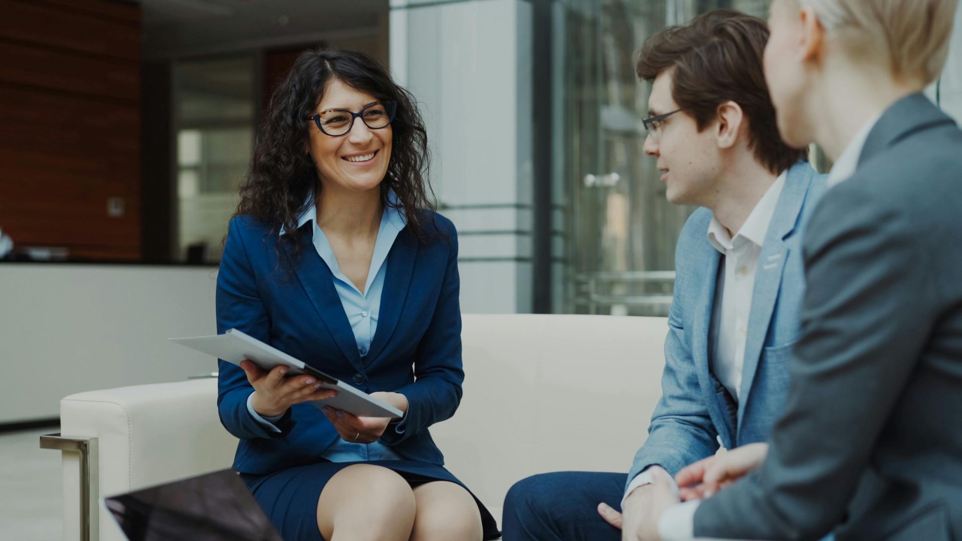 Des professionnels discutant de stratégie commerciale dans un environnement de bureau d'entreprise.