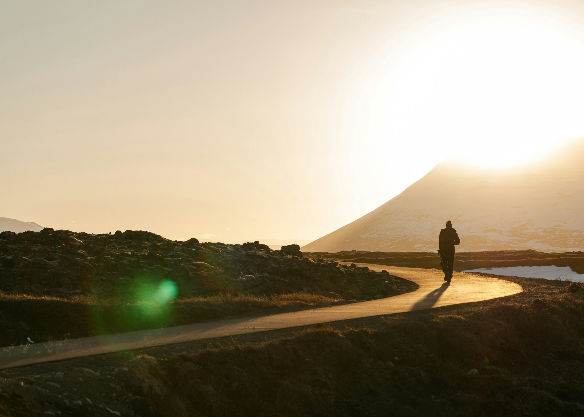 Photographie de silhouette : une personne sur une route sinueuse